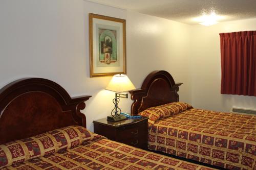 a hotel room with two beds and a lamp at Valley Hotel in Rosemead