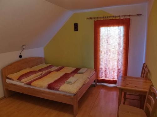 1 dormitorio con cama, ventana y mesa en Penzion a vinný sklípek Mušov, en Pasohlávky