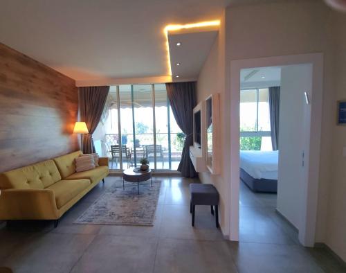 a living room with a couch and a bed at Neot Golf, Ziv's Place in Caesarea