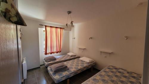 a room with two beds and a window at La Grange Saint-Jacques in Bach