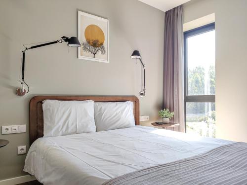 a bedroom with a bed with two lamps and a window at Quinta Dona Iria in Miranda do Corvo