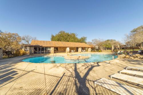 a swimming pool with a building in the background at Stylish Townhome with Shared Pool Access in Gated Complex in San Antonio