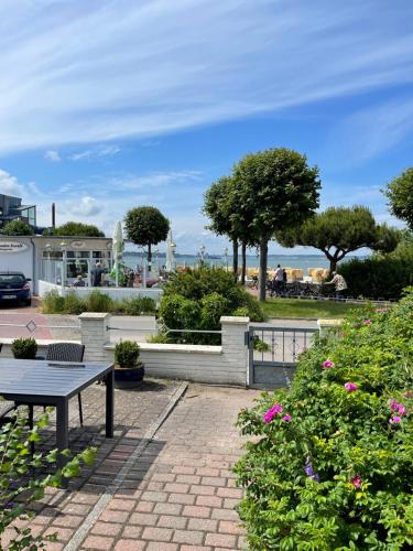a park with a bench and a table and flowers at Strandstrasse34 in Laboe