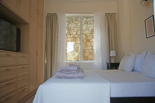 een slaapkamer met een bed met handdoeken erop bij Fereniki's place in Gaios