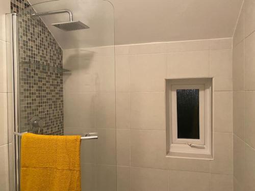 a bathroom with a shower with a yellow towel at Cheerful 2 bedroom holiday home with parking in Cleethorpes