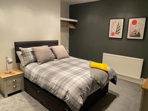 a bedroom with a bed with a plaid bedspread at Cheerful 2 bedroom holiday home with parking in Cleethorpes