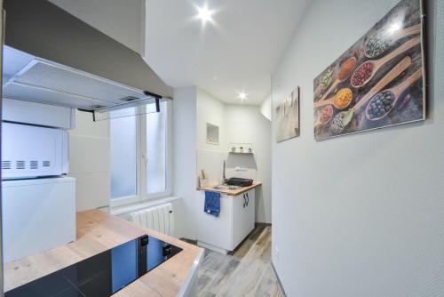 une cuisine avec un réfrigérateur blanc et un comptoir dans l'établissement Appart OPALE rdc - parking gratuit- Netflix, à Bourges