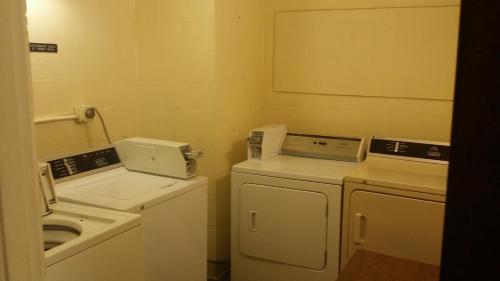 a small laundry room with a washer and dryer at Baymont by Wyndham Cookeville in Cookeville