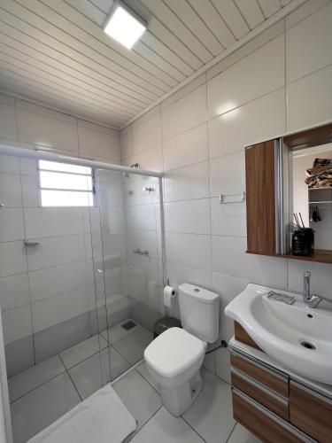a bathroom with a toilet and a shower and a sink at Pousada UpSerra in Urubici