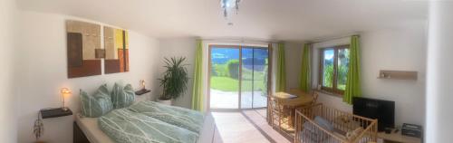 a room with a bed and a television and a balcony at Relax.Land - Apart Grinzens 90qm Ferienwohnung in Grinzens