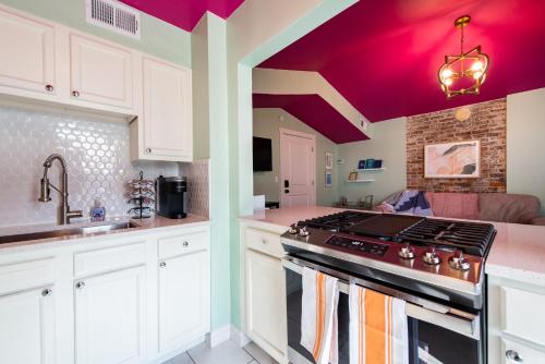 a kitchen with white cabinets and purple ceilings at Juleps And Lilies Germantown 1 Bedroom Apartment in Louisville