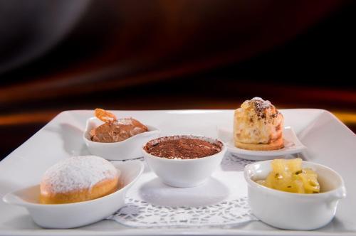 a tray with different types of desserts on it at Hotel Olden in Gstaad