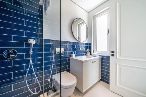 a blue tiled bathroom with a toilet and a shower at Jaden Farm House in Fethiye