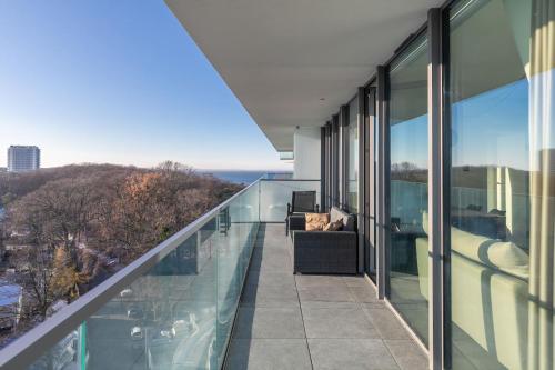 a balcony with glass walls and a view of the ocean at Your Holidays Waves in Międzyzdroje