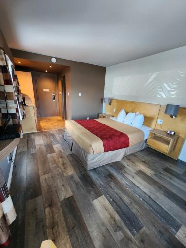 a bedroom with a large bed with a wooden floor at Hôtel le 625 in La Malbaie