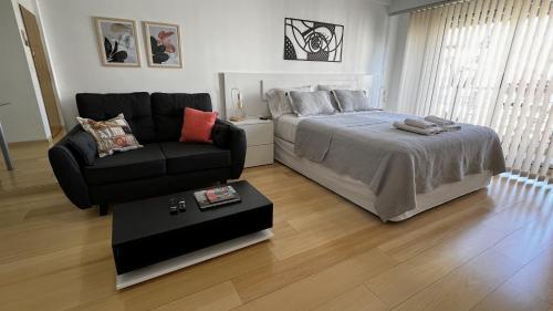 um quarto com uma cama, um sofá e uma cadeira em Petite Maison II em Buenos Aires