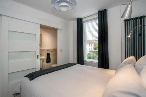 Un dormitorio con una gran cama blanca y una ventana. en Trinity Square, Margate, en Margate