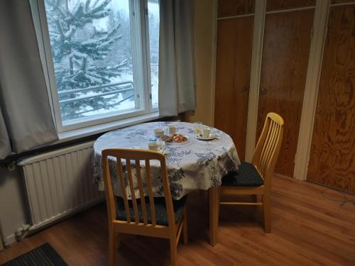 a dining room table with a table and chairs and a window at Veikkola Karstula in Karstula