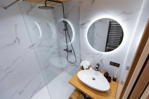 een witte badkamer met een wastafel en een spiegel bij Duplex cosy au pied des pistes vue montagne in Les Menuires