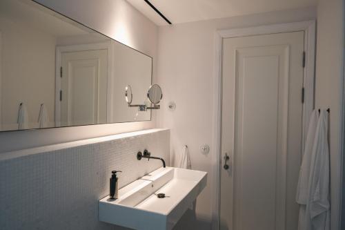 a white bathroom with a sink and a mirror at Luxury apartment lake Lago Maggiore in Germignaga