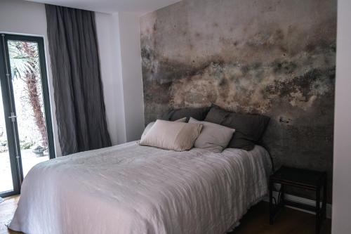 a bed in a bedroom with aastered wall at Luxury apartment lake Lago Maggiore in Germignaga