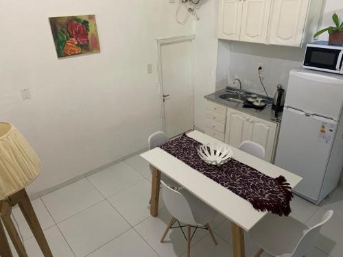 una pequeña cocina con mesa y nevera blanca en El Cerro en Posadas