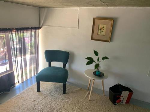 una silla azul sentada en una habitación con una mesa en El Cerro en Posadas