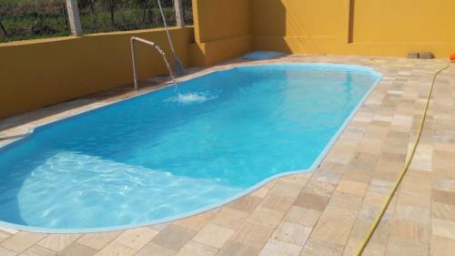 a large pool with a tile floor and blue water in it at Recanto Andrade in Presidente Prudente