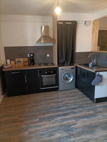 uma cozinha com um fogão, um lavatório e uma máquina de lavar louça em Appartement très spacieux en plein cœur d'agen em Agen