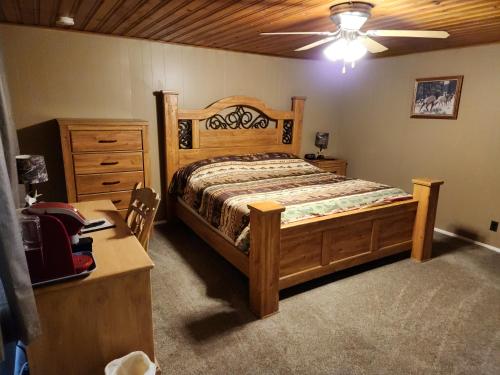 1 dormitorio con cama de madera y vestidor en Eagle Nest Fly Shack & Lodge en Eagle Nest