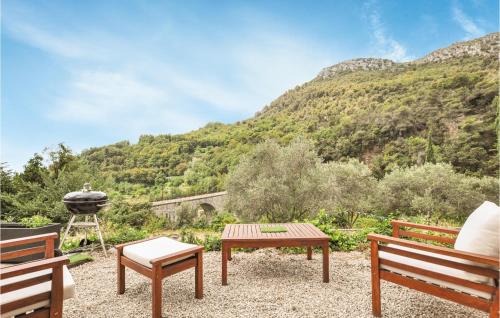 un patio avec deux bancs, un grill et des montagnes dans l'établissement Nice Home In Saint-Jeannet With Wifi, à Saint-Jeannet