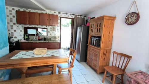 a kitchen with a wooden table and a refrigerator at Apt Recanto dos Golfinhos-Centro de Pipa in Pipa