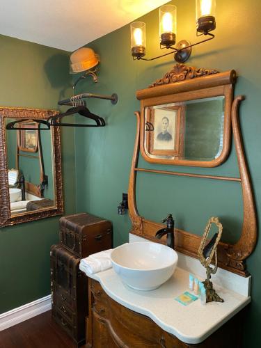 a bathroom with a sink and a mirror at Phantom History House - Portrait Room in Tampa