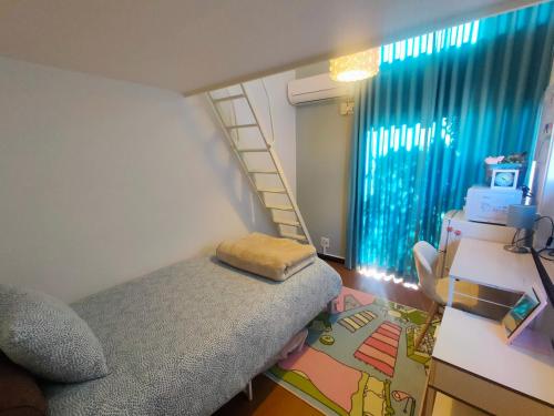 een kleine slaapkamer met een bed en een ladder bij Glen Stage 中浦和 in Saitama