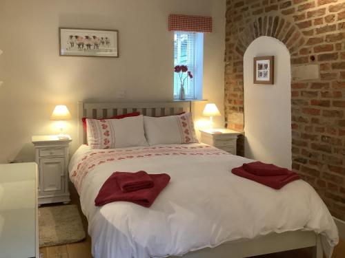 a bedroom with a large bed with red towels on it at Rustys Cottage in Skirpenbeck