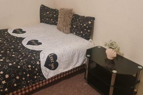 a bedroom with a bed with black and white comforter at Modern flat in Jerviston Court in Motherwell