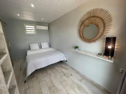 a bedroom with a bed and a mirror on the wall at The Bay View in Les Trois-Îlets