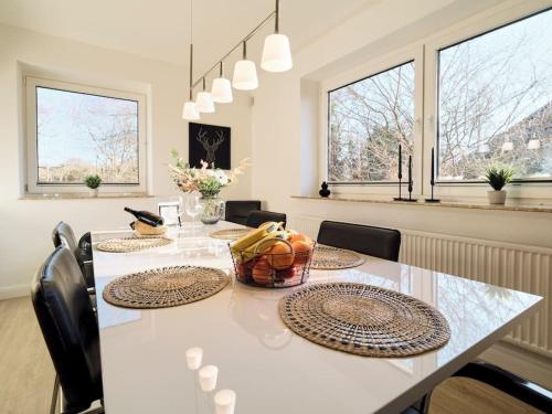 comedor con mesa, sillas y ventanas en Ferienwohnung "Gilde" hyggelig mit Blick ins Grüne en Glücksburg
