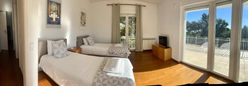 a bedroom with two beds and a balcony at Estoril dream in Estoril