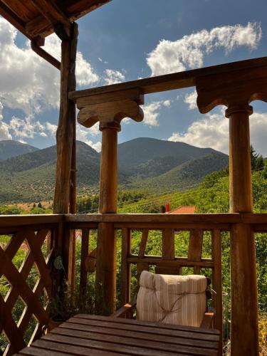 Lykos Mansion في Kápsas: كرسي على شرفة مع جبال في الخلفية