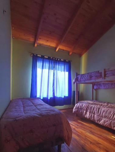 1 dormitorio con 2 camas y ventana en Departamento el encuentro en El Bolsón