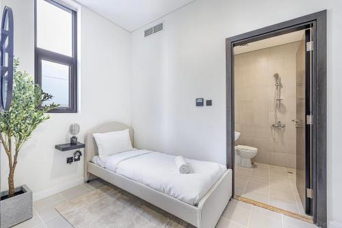 a white bathroom with a bed and a shower at Daniels Golf Course 5BR Villa with Private Pool in Dubai
