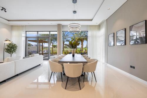 a dining room with a table and chairs at Daniels Golf Course 5BR Villa with Private Pool in Dubai