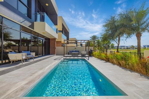 a swimming pool in the backyard of a house at Daniels Golf Course 5BR Villa with Private Pool in Dubai