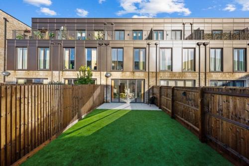 a house with a yard of green grass at Amazing new built townhouse with garden in London in Hendon