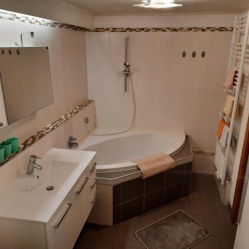a bathroom with a tub and a sink at Landgasthaus Appartement Birkegg in Leutasch