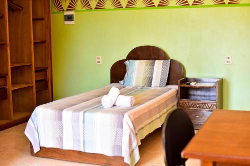 een slaapkamer met een bed met twee handdoeken erop bij Palmas Park Hotel y Restaurant in Obligado