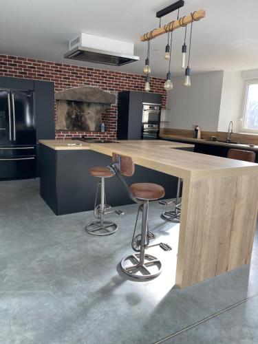 une cuisine avec un comptoir et deux tabourets dans l'établissement Le Terminus de Jobourg, à Jobourg