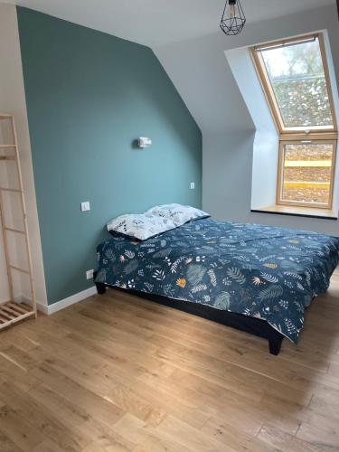 une chambre avec un lit aux murs bleus et une fenêtre dans l'établissement Le Terminus de Jobourg, à Jobourg