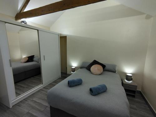 una camera da letto con un letto con due cuscini e uno specchio di Queens Holiday Apartment a Pembroke Dock